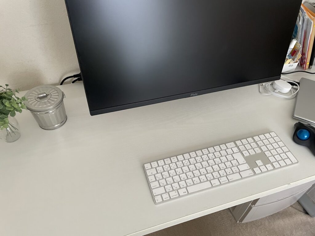 27インチほどのモニターとキーボードを置いて使用しているニトリの白いデスク